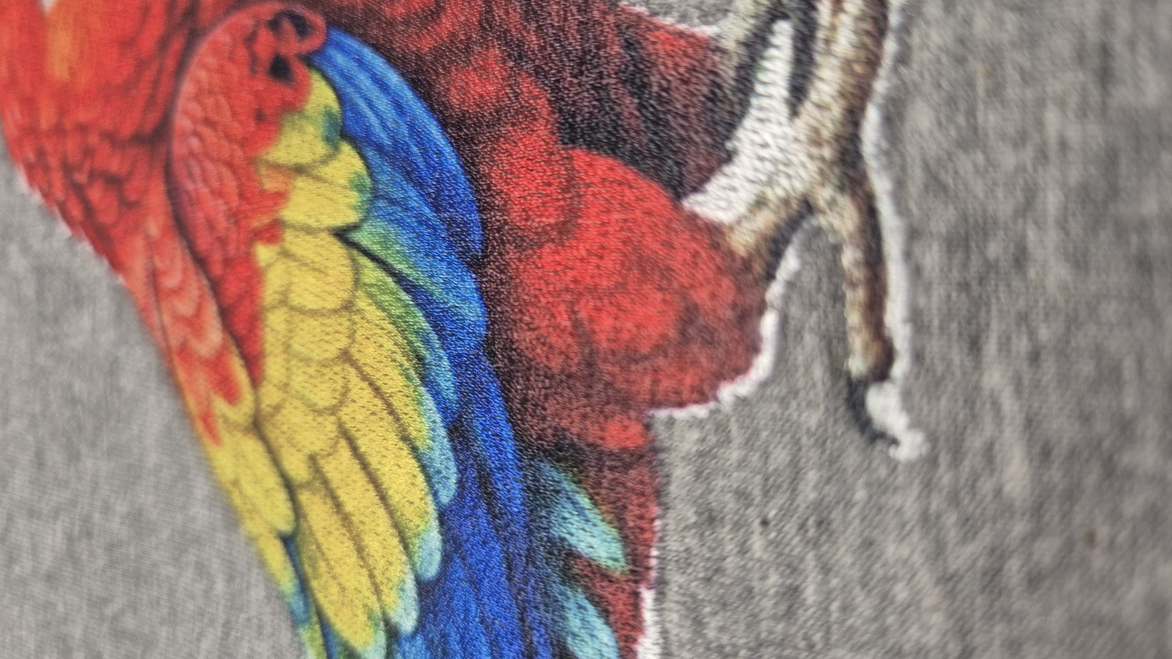 Ta technika pozwala na płynne, fotograficzne przenoszenie koloru na haft, wewnątrz struktury nici. Tradycyjna igła nie byłaby w stanie oddać tak skomplikowanego, fotorealistycznego wzoru na piórach. 